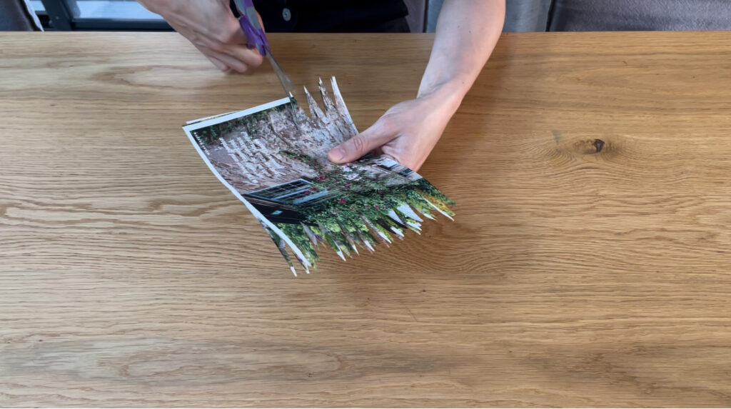 Woman cutting the edges of pieces of paper into spikes