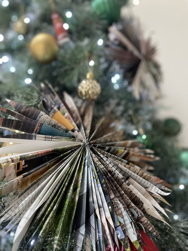 Christmas tree decorated with golden baubles and two paper stars