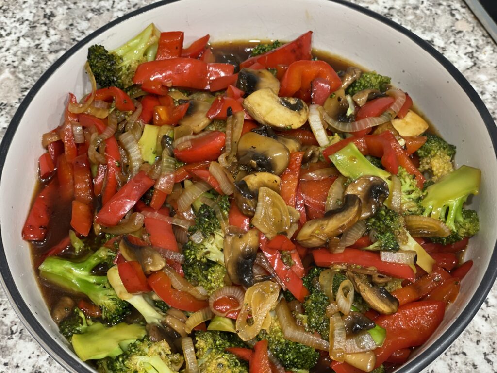 Vegetable stir fry in white bowl on granite bench top