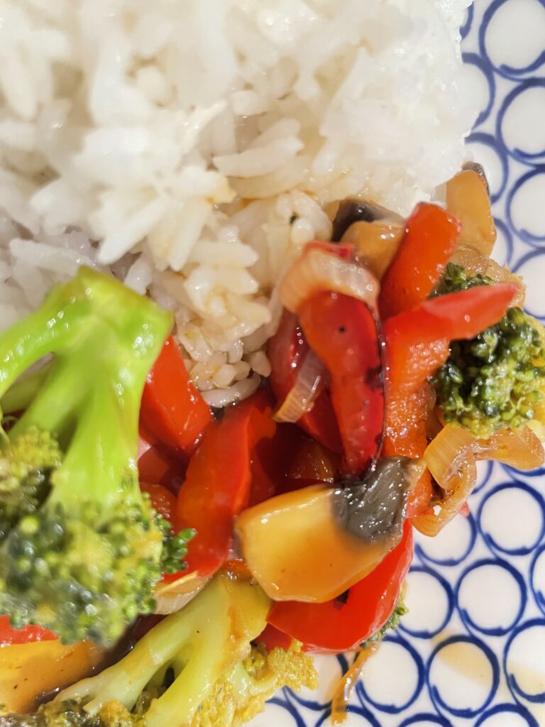 Close up shot of white and blue bowl filled with white rice and vegetables