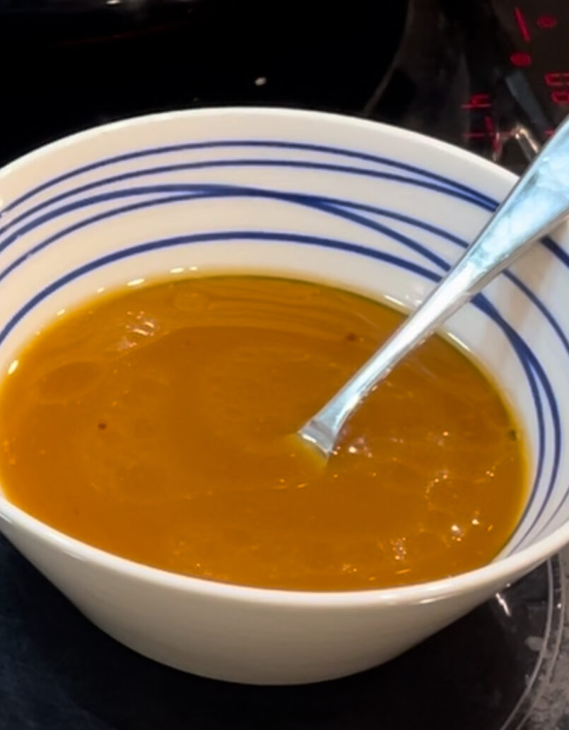 White and blue bowl filled with yellow dressing 