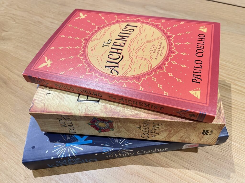 Red, Yellow and Blue book stacked on wooden table