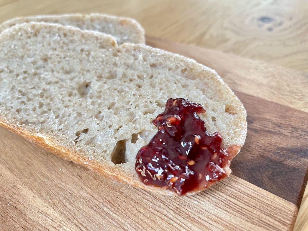 Close up shot of rustic bread with red jam