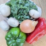 Mixture of green, brown and red vegetables on wooden table