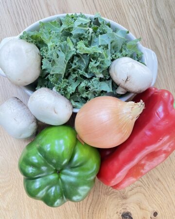 Mixture of green, brown and red vegetables on wooden table