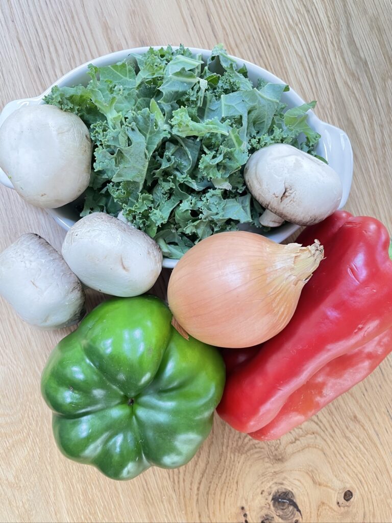 Mixture of green, brown and red vegetables on wooden table