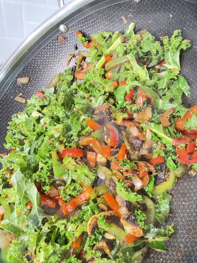 Kale with mushroom and capsicum in large pan