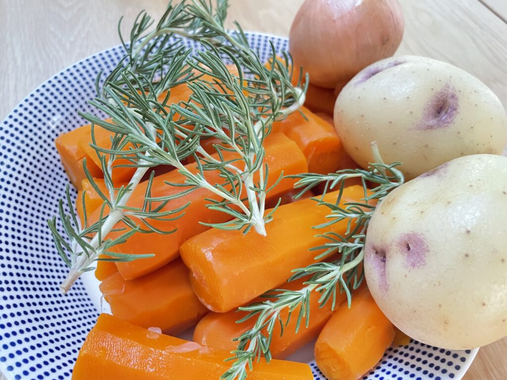 Carrots, potatoes and rosemary on plate