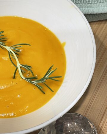 Rosemary infused carrot and potato soup served in bowl