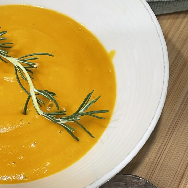 Rosemary infused carrot and potato soup served in bowl