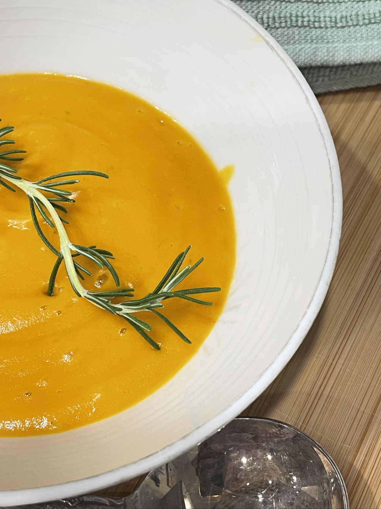 Rosemary infused carrot and potato soup served in bowl