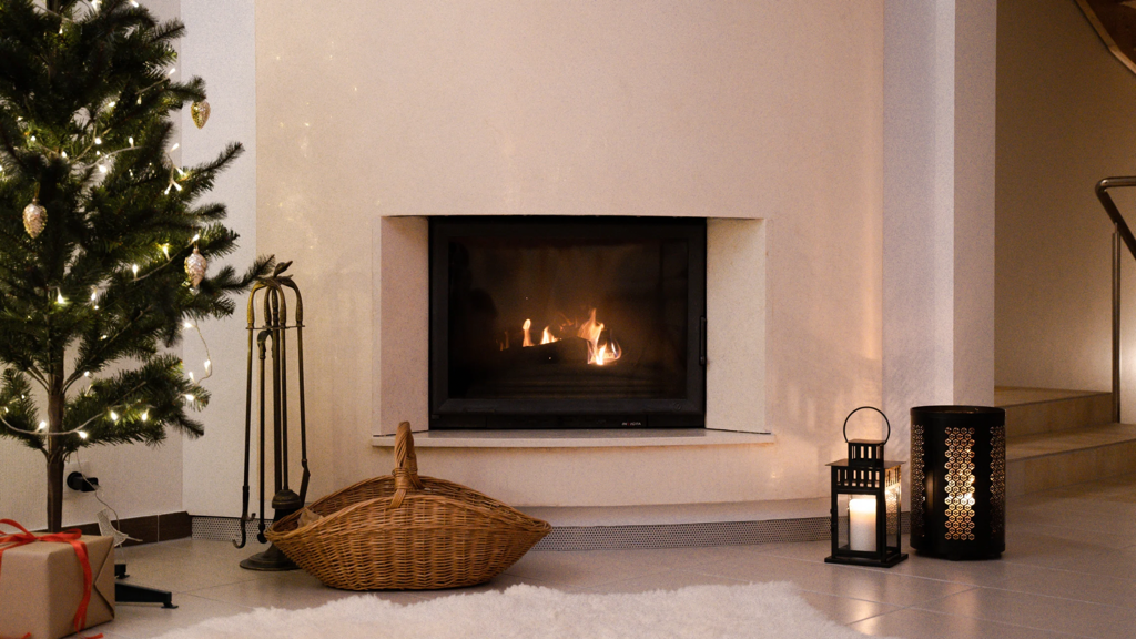 White wall with inset fireplace next to Christmas tree and candles