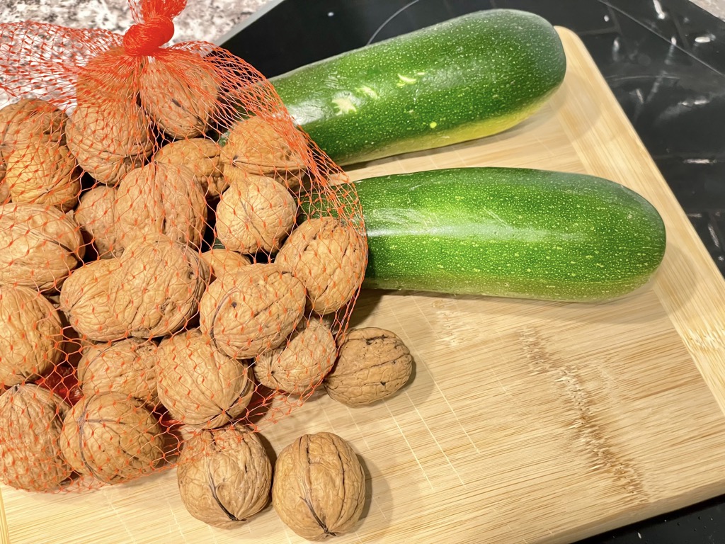 Net of walnuts and zucchini on wooden board