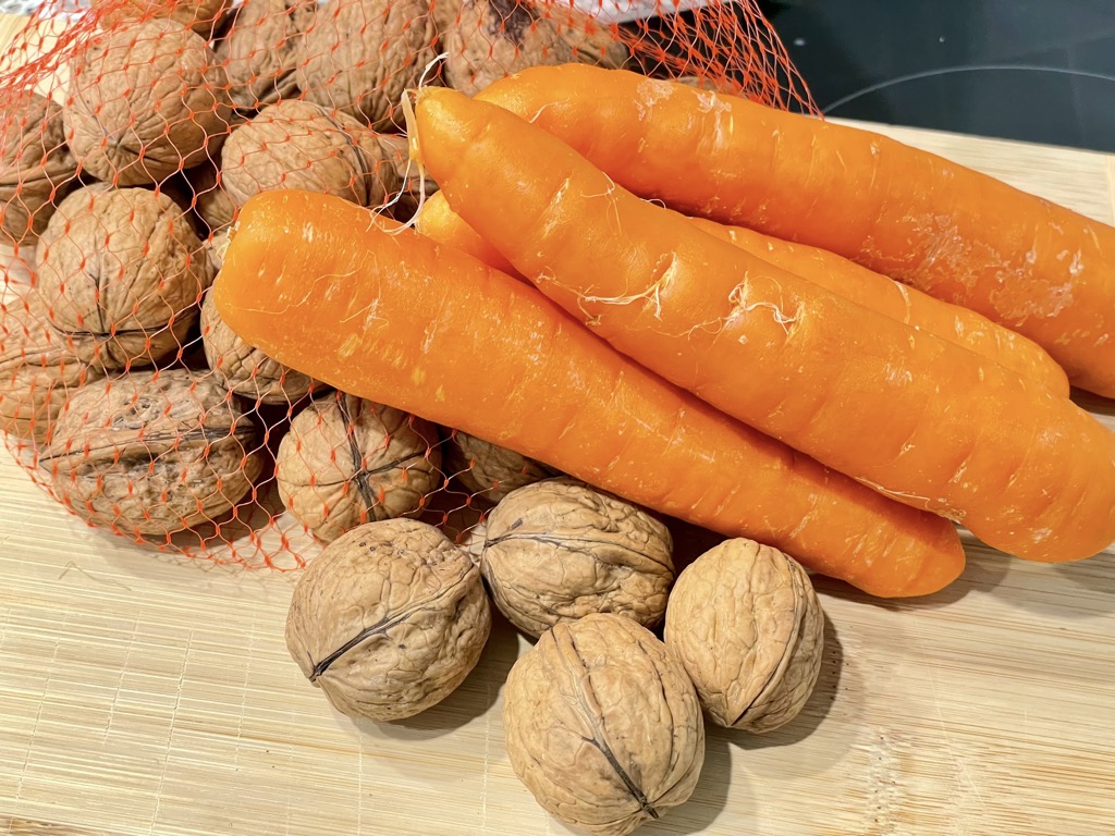 Carrots and walnuts on wooden board