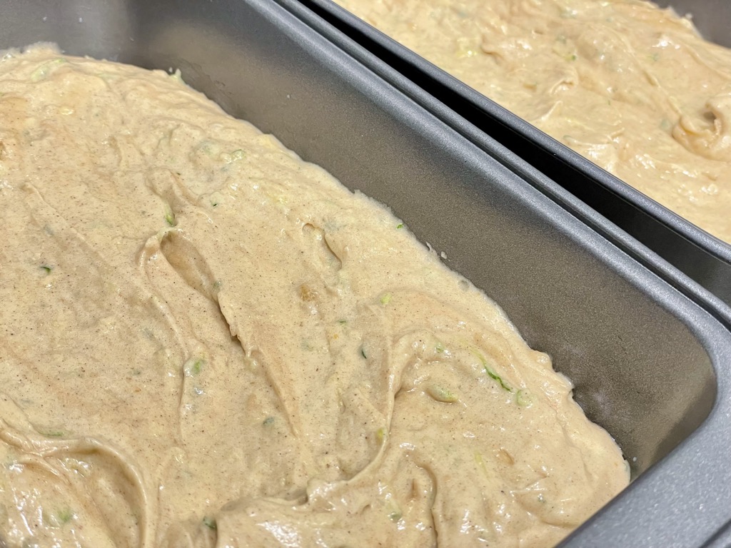 Sourdough discard zucchini bread dough in silver baking tins