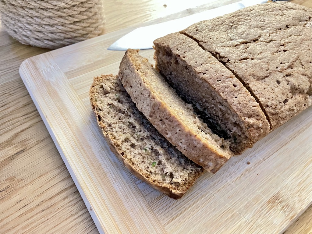 Sourdough discard zucchini bread, sliced on wooden board