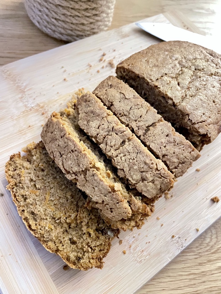 Wooden board with sliced sourdough discard carrot cake without frosting