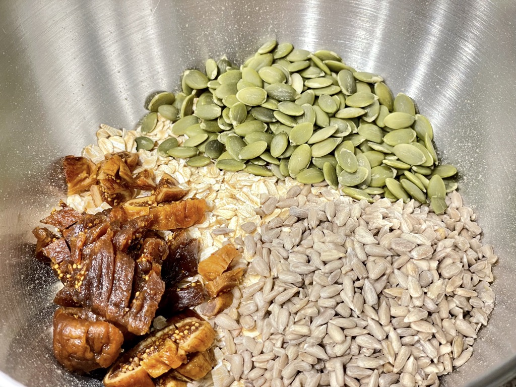 Oats, seeds and dried fruit in silver bowl