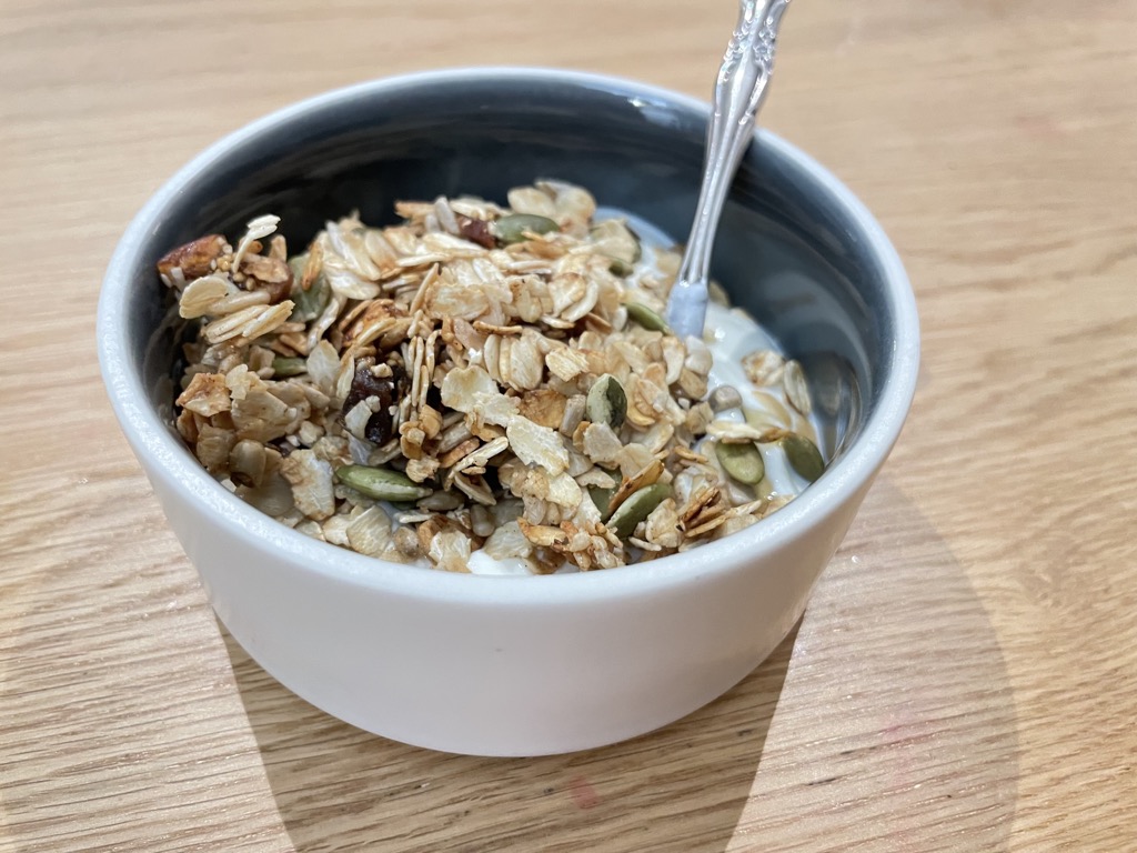 Bowl with spoon, filled with yoghurt and granola