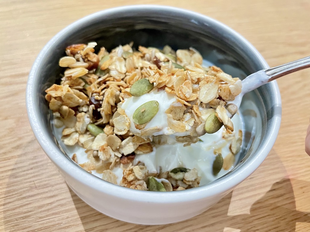 Silver spoon lifting yoghurt and granola out of bowl