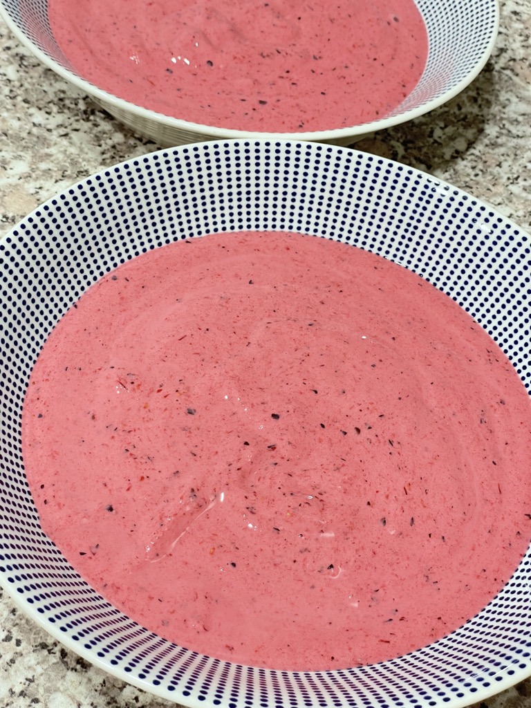 Two bowls filled with pink smoothie mix