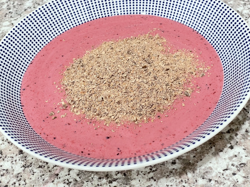 Close up shot of berry smoothie bowl with chocolate toppings