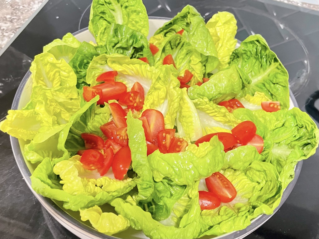 Bowl of salad greens with tomatoes