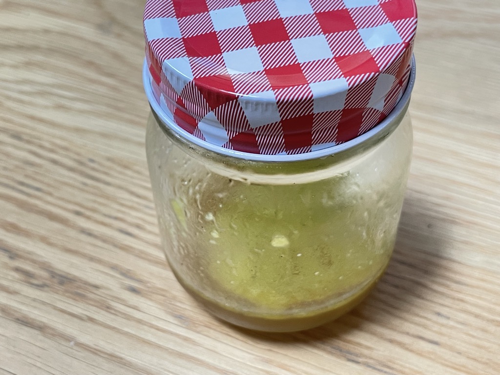 Close up shot of closed jar filled with salad dressing