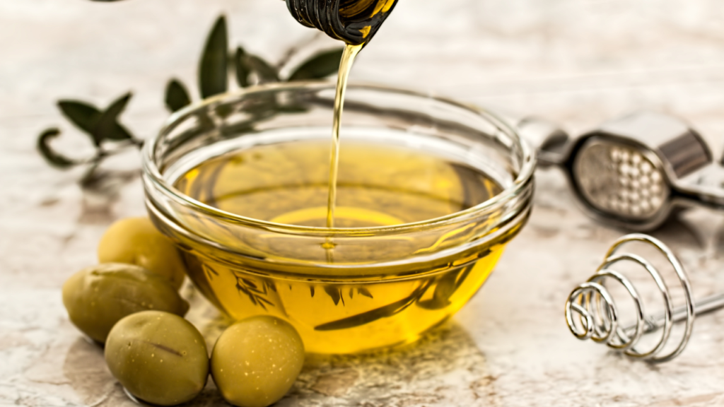 Olive oil being poured into glass jar