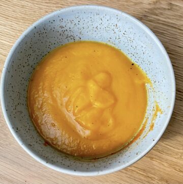 Top down shot of sweet potato soup in bowl on table