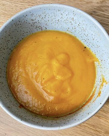 Top down shot of sweet potato soup in bowl on table