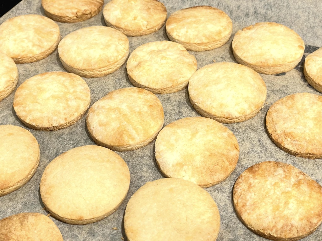 Baking tray with golden baked shortbread rounds