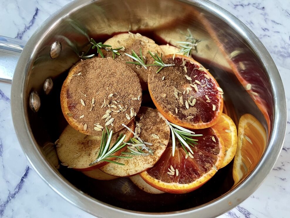 Citrus, apple, herbs and spices in silver pot