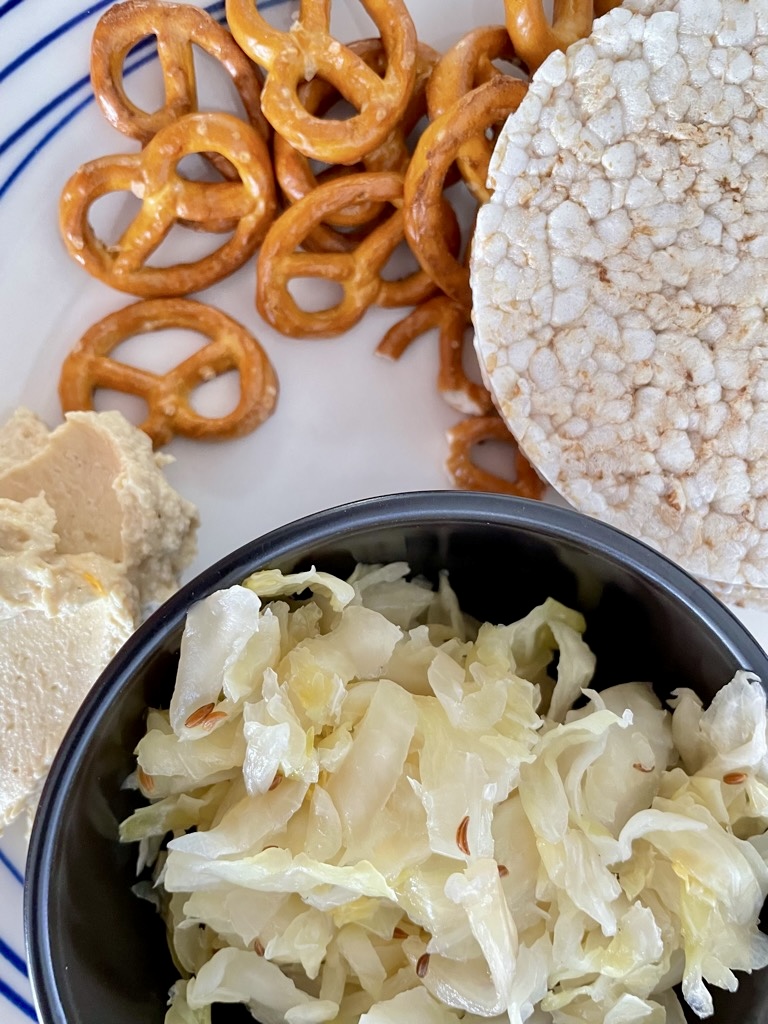 plate with Traditional German Sauerkraut, pretzels, hummus and rice cakes