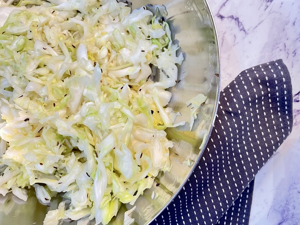 raw cabbage with caraway seeds in silver bowl