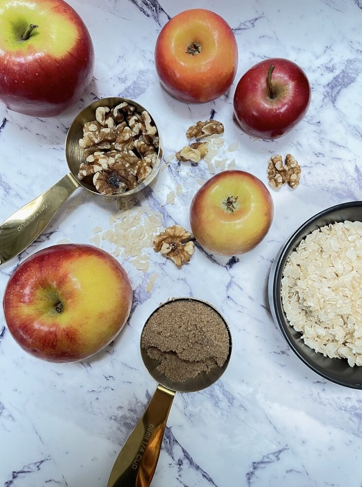 Warming bratapfel porridge with rice flakes ingredients laid out on marble bench