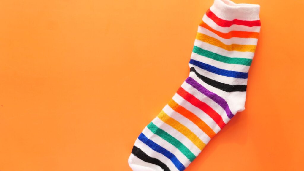 Colourful striped sock on orange background