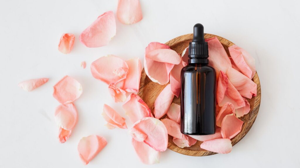 Small brown glass bottle on bed of rose petals