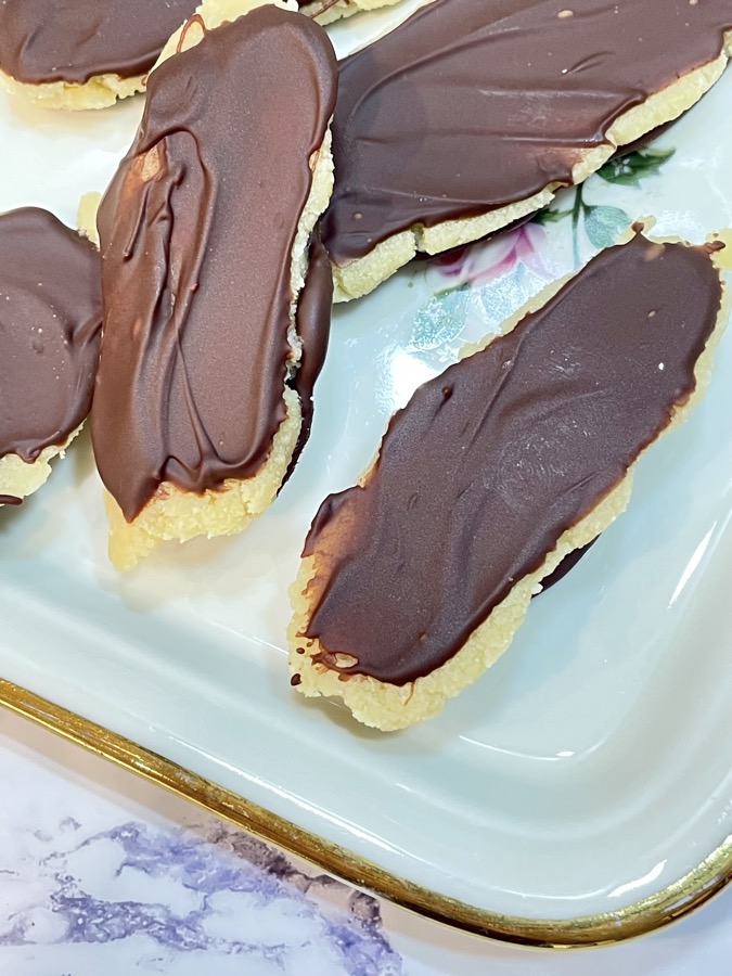 Marzipan in chocolate on white plate