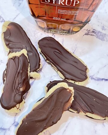 Marzipan filled chocolate bars in front of bottle of maple syrup