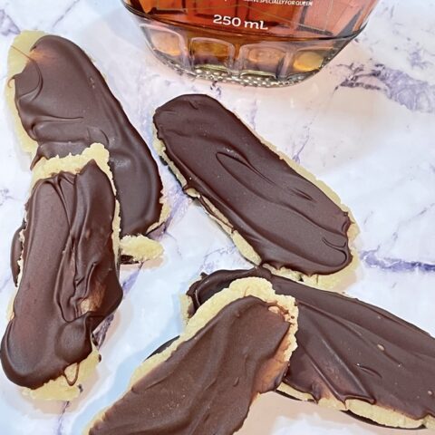 Marzipan filled chocolate bars in front of bottle of maple syrup