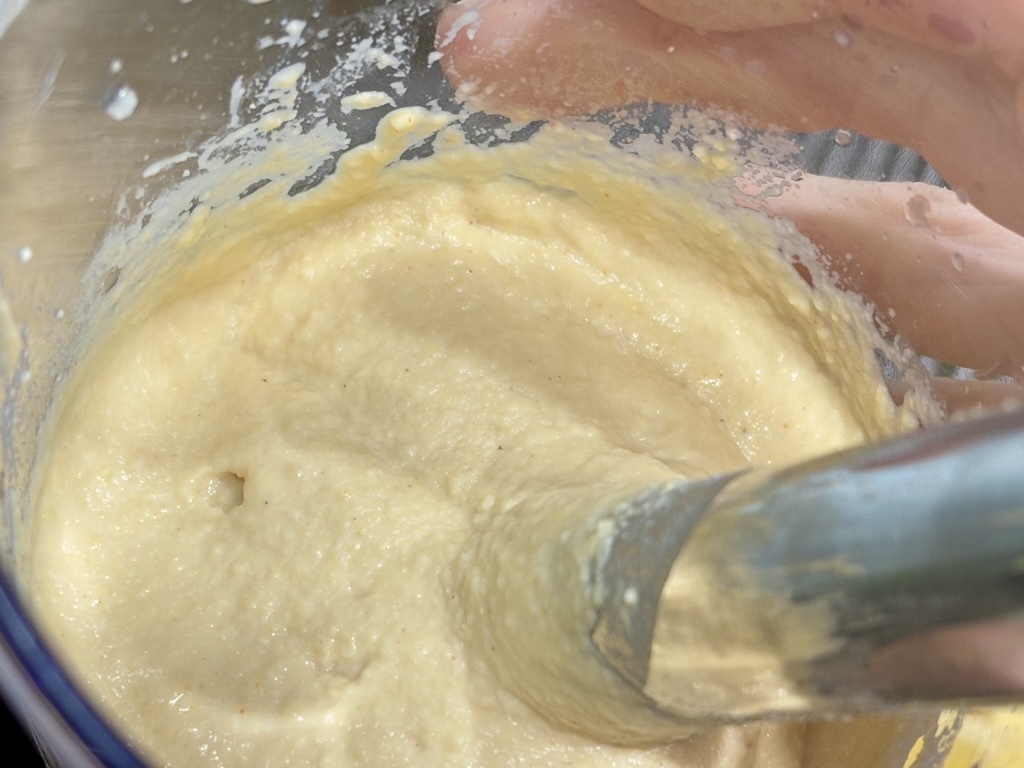 Creamy hummus being blended in clear container