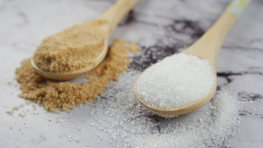 Wooden spoons of white and brown sugar