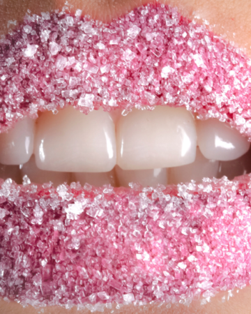 Close up shot of pink lips covered with sugar scrub