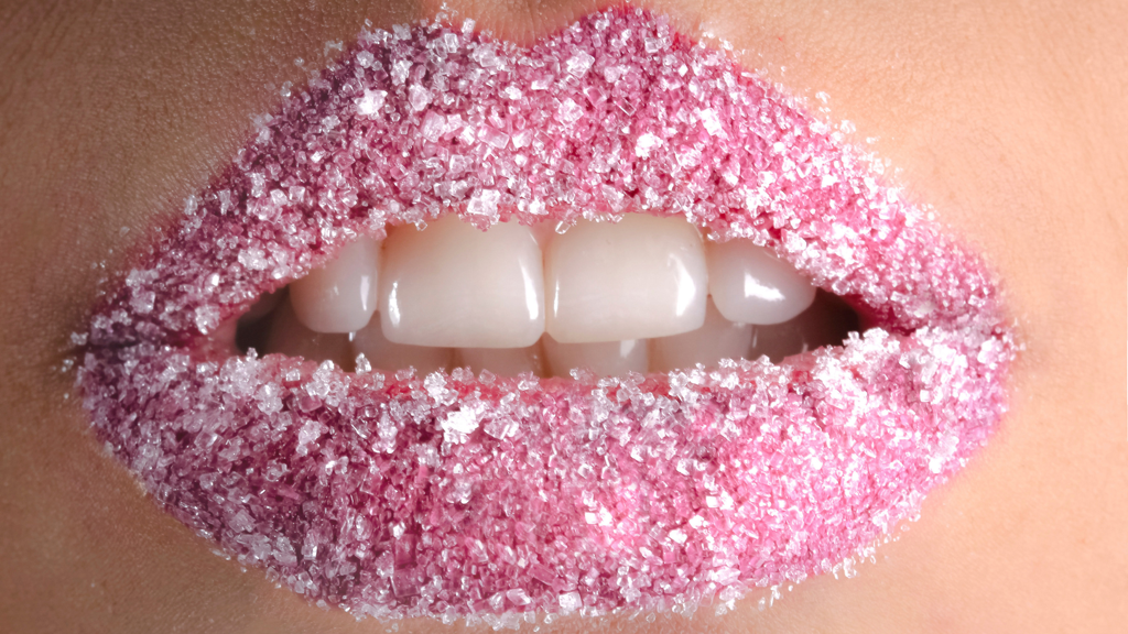 Close up shot of pink lips covered with sugar scrub