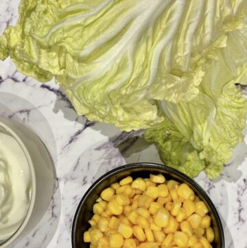 Napa cabbage, bowl of corn and bowl of yoghurt on kitchen bench