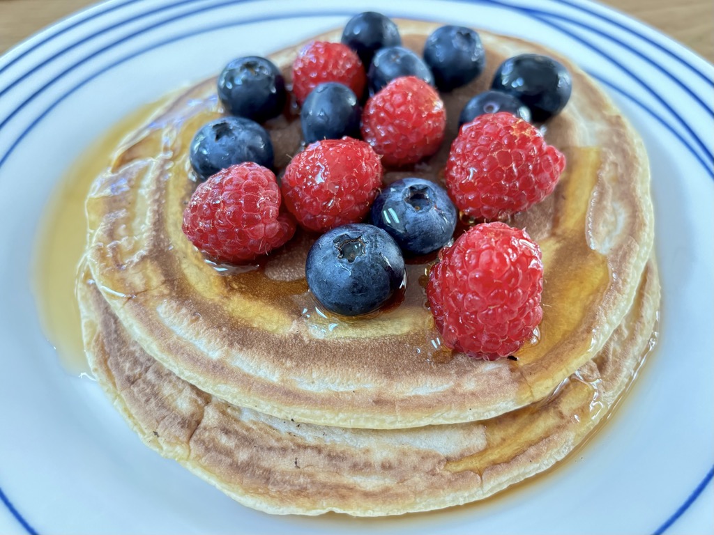 Pancakes topped with berries and syrup