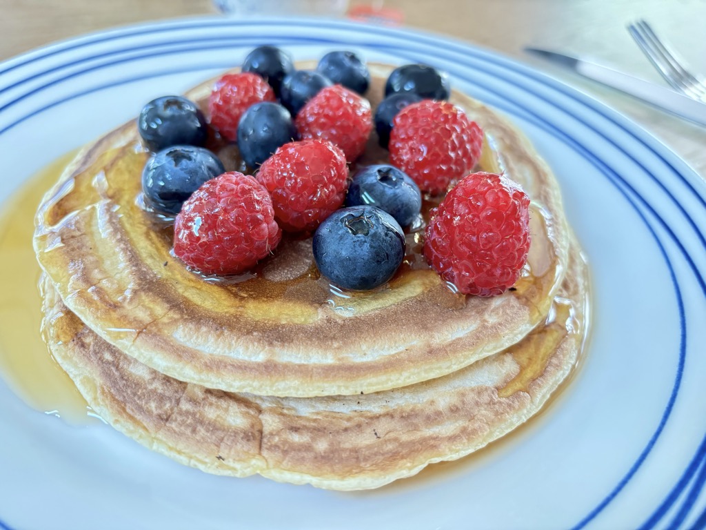 Pancake stack topped with raspberries and blueberries