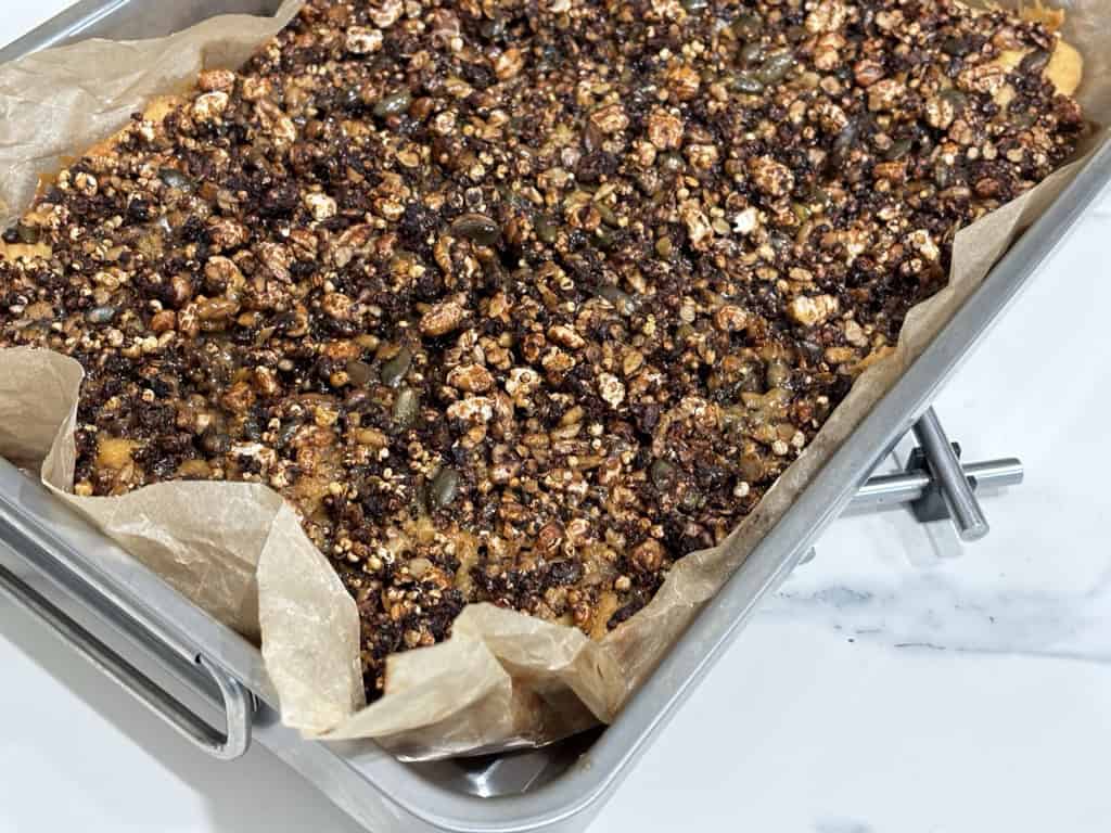 Silver tray filled with block of baked granola slice