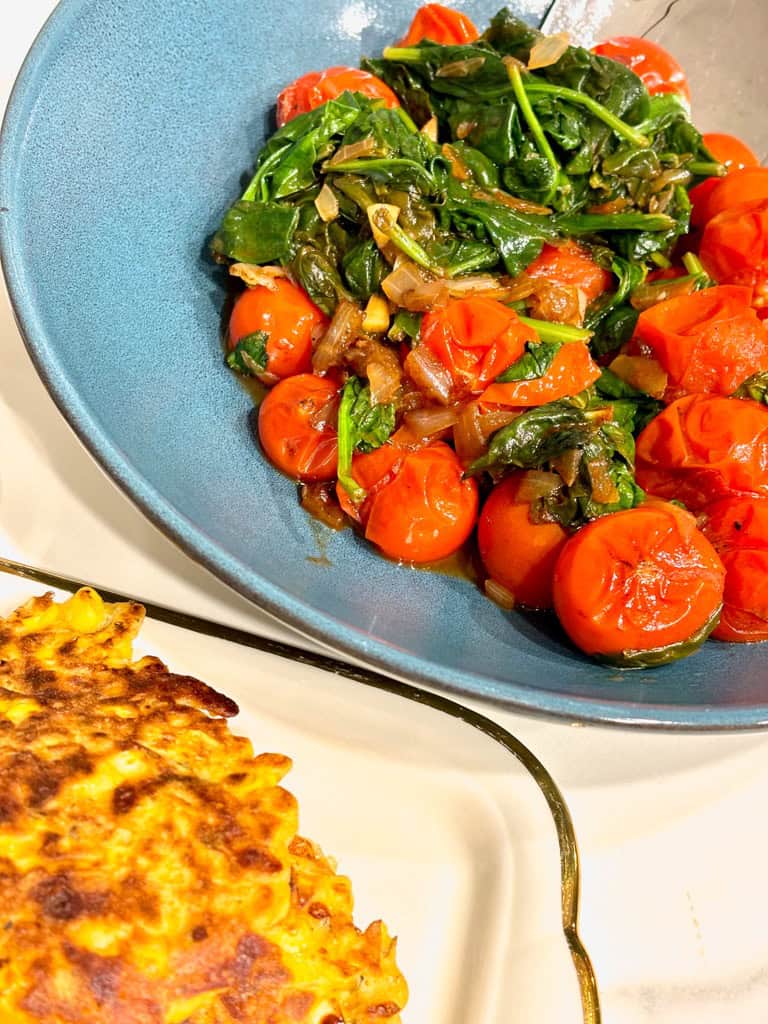 sautéed tomatoes and spinach in blue serving bowl